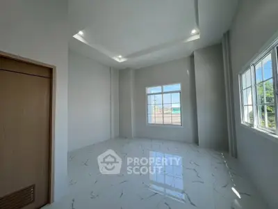Spacious modern room with high ceilings and large windows offering abundant natural light.