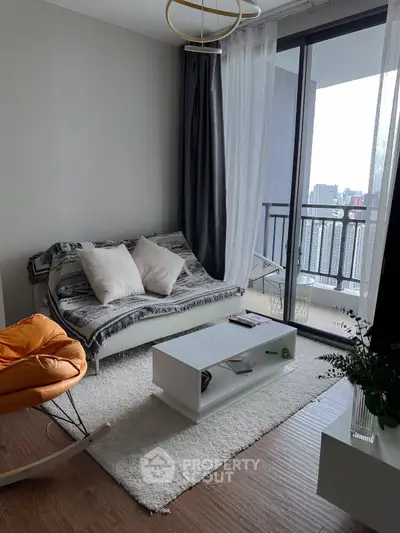Modern living room with cozy sofa, stylish decor, and balcony view in urban apartment.