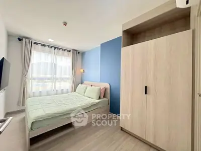 Modern bedroom with large window, stylish wardrobe, and cozy bed in a bright apartment.