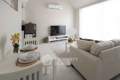 Cozy living room with modern decor, featuring a comfortable sofa, TV, and dining area, perfect for relaxation.