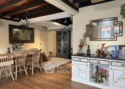 Charming living room with rustic wooden beams and elegant dining area, perfect for cozy gatherings.