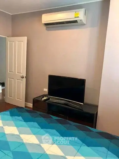 Cozy bedroom with air conditioning and modern TV setup, perfect for relaxation.