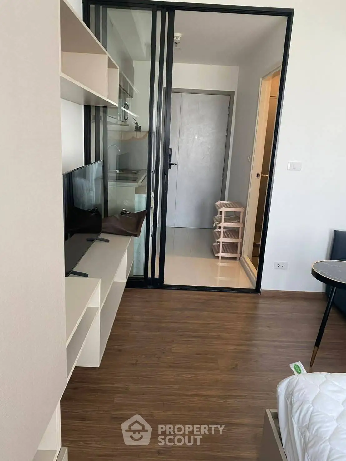 Modern apartment interior with sliding glass doors and wooden flooring