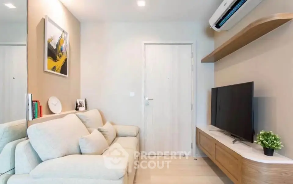 Modern living room with cozy sofa, wall-mounted TV, and stylish decor in a contemporary apartment.