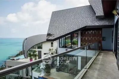 Stunning ocean view from modern balcony with glass railing and contemporary architecture.