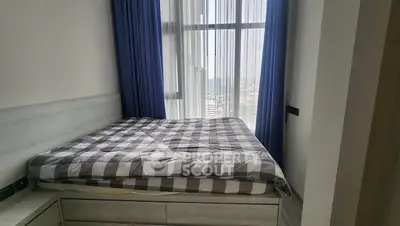 Cozy bedroom with large window and blue curtains in modern apartment