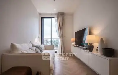 Modern living room with elegant decor and large window offering natural light and city view.