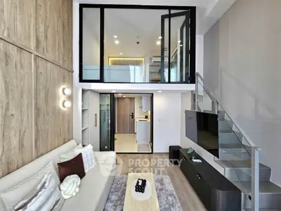 Modern loft-style living room with mezzanine, sleek staircase, and stylish decor