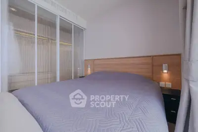 Modern bedroom with sleek design and cozy ambiance, featuring a comfortable bed and stylish lighting.