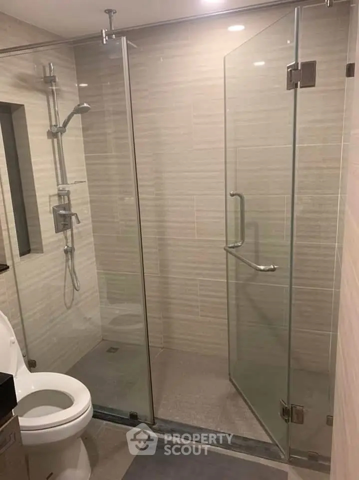 Modern bathroom with glass shower enclosure and sleek fixtures.