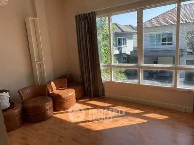 Bright living room with large window and modern furniture in a cozy home setting.