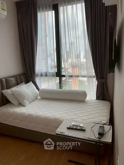Cozy bedroom with city view, featuring a comfortable bed and modern decor.