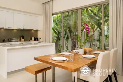 Modern kitchen with open layout and elegant dining area overlooking lush garden.