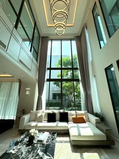 Luxurious living room with high ceilings and large windows offering abundant natural light.