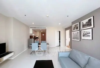 Modern living room with sleek furniture and open kitchen layout in a stylish apartment.
