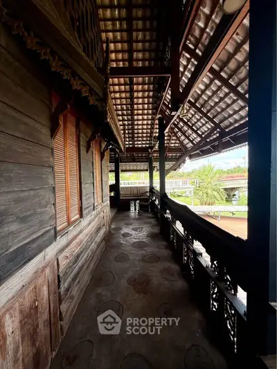 Charming traditional wooden balcony with intricate carvings and scenic views, perfect for relaxation and enjoying nature.