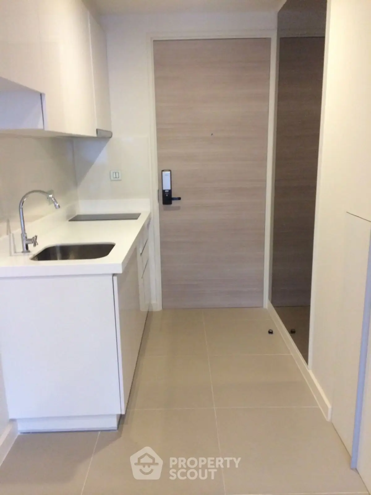 Modern minimalist kitchen with sleek white cabinetry and integrated appliances.