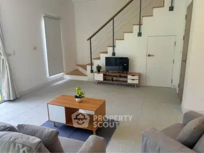 Modern living room with stylish staircase and sleek furniture