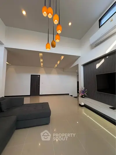 Spacious modern living room with elegant lighting and sleek design, perfect for contemporary living.