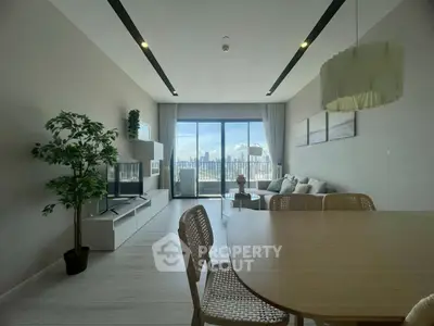 Modern living room with city view, stylish furniture, and large windows for natural light.