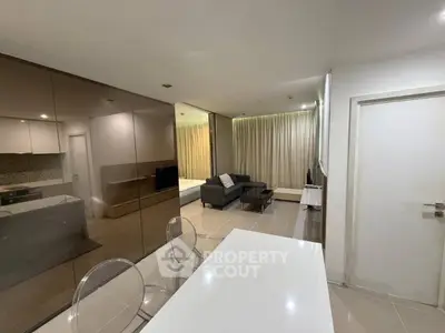 Modern open-plan living room with sleek furniture and glossy finishes in a contemporary apartment.