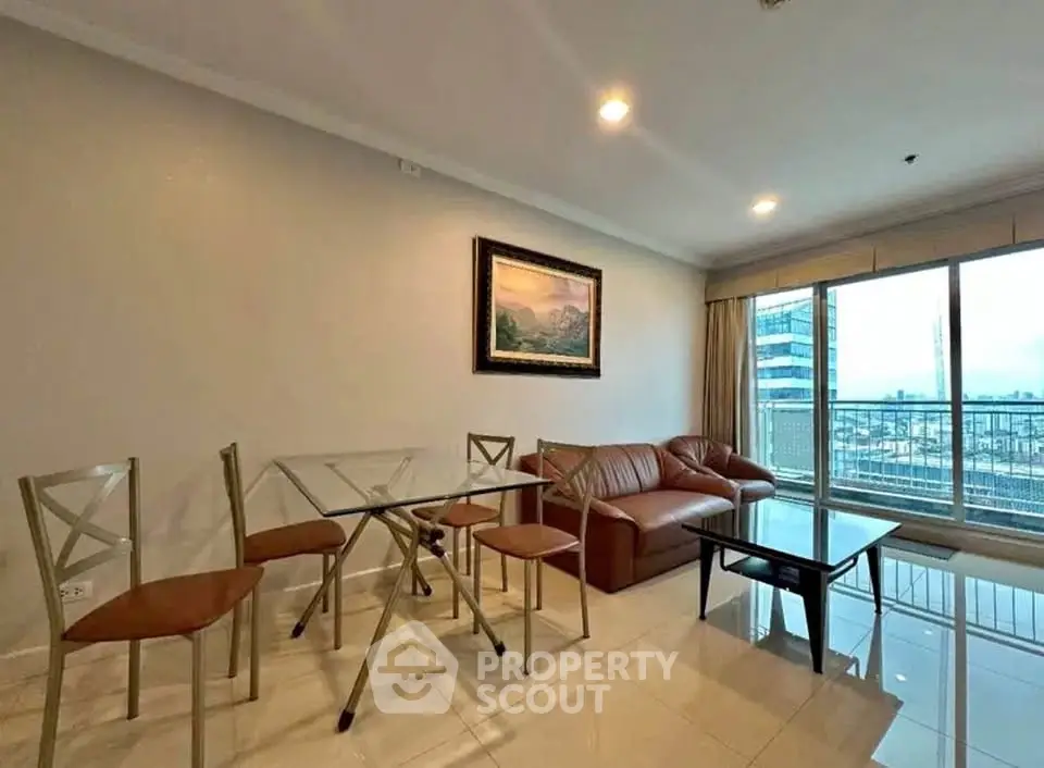 Spacious living room with modern furniture and city view balcony in high-rise apartment.