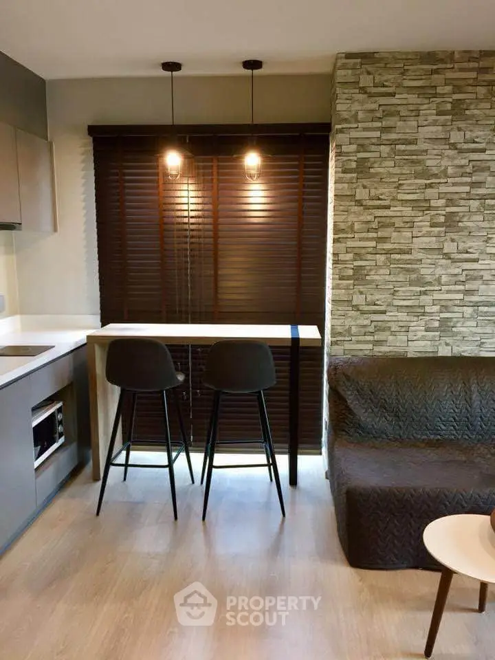 Modern kitchen with stylish bar stools and stone accent wall