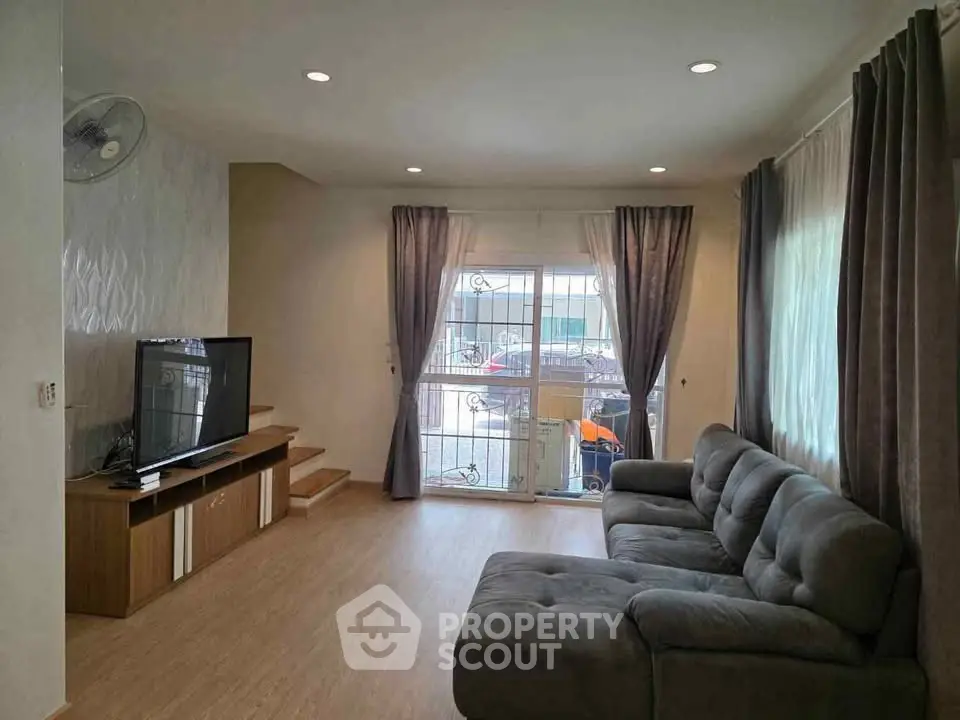 Spacious living room with modern decor and large window for natural light.