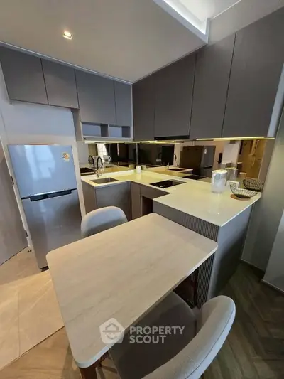 Modern kitchen with sleek cabinetry and compact dining area