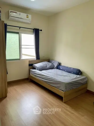 Cozy bedroom with wooden flooring and natural light