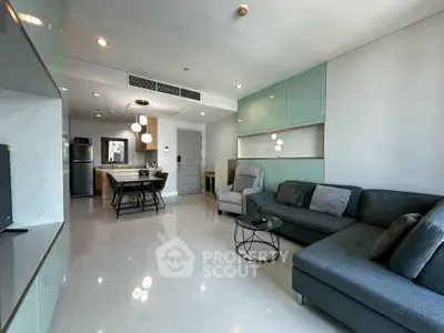 Modern living room with open kitchen, stylish furniture, and sleek design in a contemporary apartment.