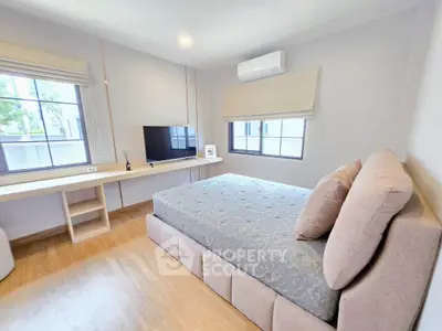 Spacious bedroom with modern decor and large windows for natural light