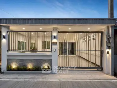 Modern gated house exterior with sleek design and ambient lighting