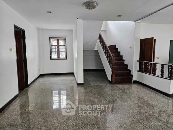 Spacious interior with polished floors and elegant staircase in modern home