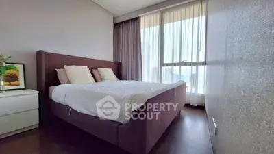 Spacious bedroom with large window and elegant decor in modern apartment