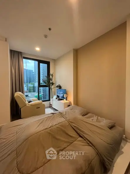 Cozy bedroom with city view, featuring a comfortable bed and modern decor.