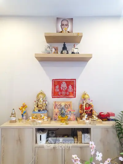 Beautifully decorated spiritual altar in a serene living space with wooden shelves and vibrant statues.