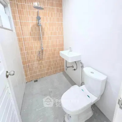 Modern bathroom with sleek shower and compact toilet in minimalist design.