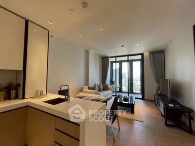 Modern open-plan living room with kitchen, featuring sleek design and city view balcony.