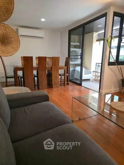 Spacious living room with modern furniture and balcony access in a stylish apartment.
