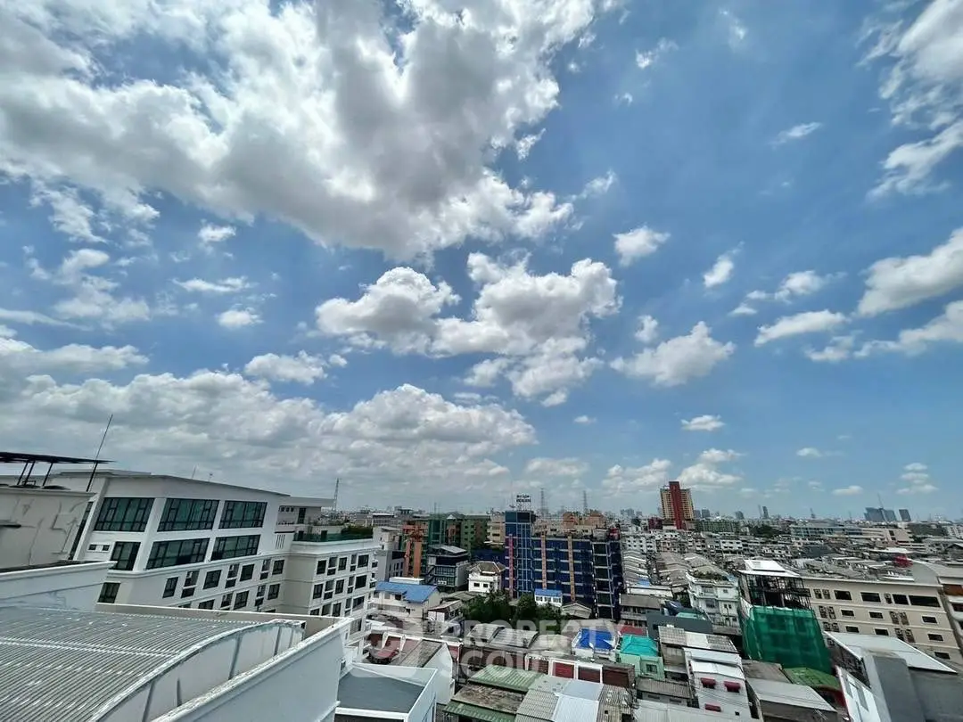 Stunning cityscape view with blue sky and clouds from a high vantage point.