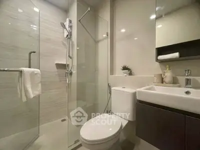 Modern bathroom with glass shower and sleek fixtures in a contemporary home.