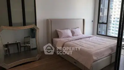 Modern bedroom with elegant decor and large mirror, featuring a cozy bed and city view.
