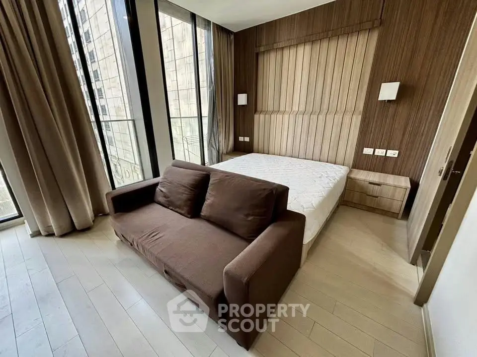 Modern bedroom with floor-to-ceiling windows and stylish decor in urban apartment