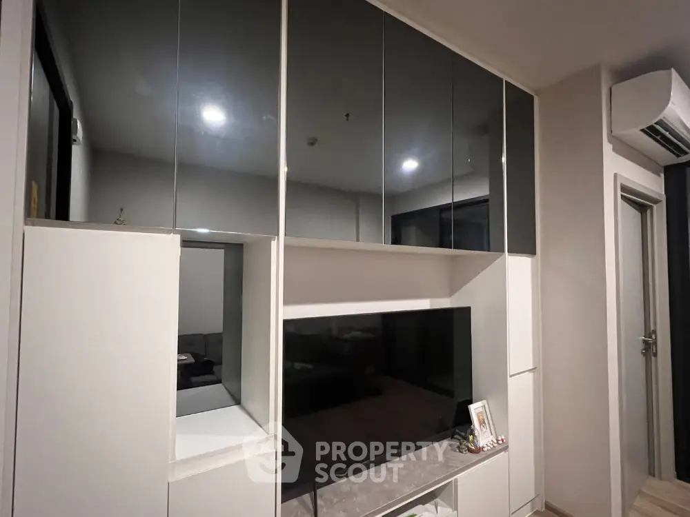 Modern living room with sleek built-in cabinets and air conditioning unit