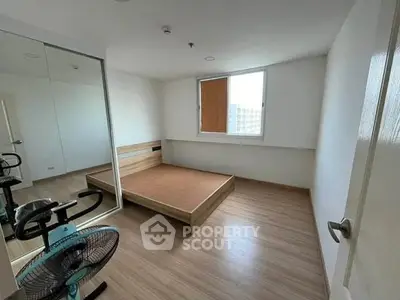 Spacious bedroom with mirrored closet and wooden flooring in modern apartment.
