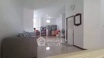 Spacious open-layout living room with modern kitchen appliances and sleek design.