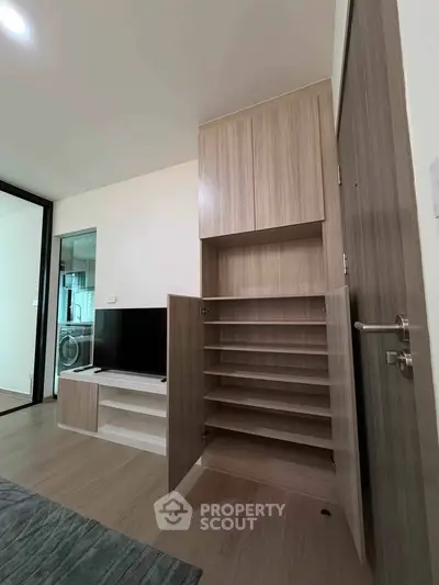 Modern living room with built-in storage and TV unit, showcasing sleek design and functionality.