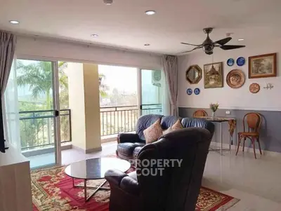 Spacious living room with elegant decor and balcony view, perfect for relaxation and entertaining.