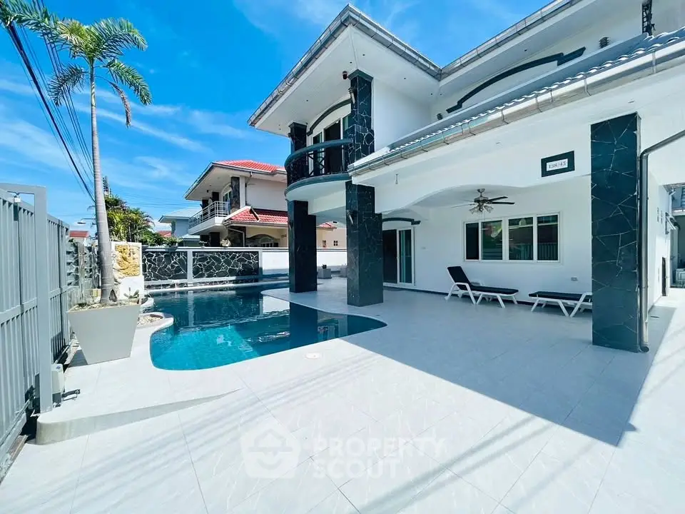 Luxurious modern villa with private pool and spacious outdoor area under clear blue sky.